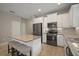 Open kitchen with granite island, stainless appliances, and white cabinets offers a functional and stylish cooking space at 6408 Seasound Dr, Apollo Beach, FL 33572