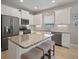 Bright kitchen features white cabinets, stainless appliances, granite countertops, and seating at the island at 6408 Seasound Dr, Apollo Beach, FL 33572