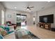 Comfortable living room with a fan, large TV, and sliding glass doors that bring in natural light at 6408 Seasound Dr, Apollo Beach, FL 33572