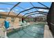 Enclosed pool area with a spa, a waterfall feature, and a blue basketball hoop for enjoyment at 6408 Seasound Dr, Apollo Beach, FL 33572