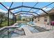 Relaxing screened-in pool and spa area featuring a waterfall feature, cool decking and clear blue skies at 6408 Seasound Dr, Apollo Beach, FL 33572