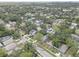 An aerial shot showcases a tree-filled neighborhood with diverse homes and a distant cityscape at 659 26Th S Ave, St Petersburg, FL 33705