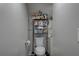 Simple bathroom features a toilet, a white sink and vanity, and shelving for storage at 659 26Th S Ave, St Petersburg, FL 33705