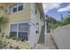 Charming yellow exterior of building with white trim and front door and stairway entrance at 659 26Th S Ave, St Petersburg, FL 33705