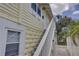 Charming yellow exterior of building with white trim and front door and stairway entrance at 659 26Th S Ave, St Petersburg, FL 33705