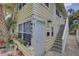 Charming yellow exterior of building with white trim and front door and stairway entrance at 659 26Th S Ave, St Petersburg, FL 33705