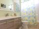 Bright bathroom features a vanity with tropical-themed shower curtain and art at 6804 Pleasant Oaks Pl, Riverview, FL 33578