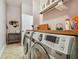 Bright laundry room featuring modern appliances, storage, and open shelving at 6804 Pleasant Oaks Pl, Riverview, FL 33578