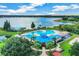 Stunning aerial view of the community pool, featuring a lake backdrop and lush landscaping, creating a resort-style living experience at 6804 Pleasant Oaks Pl, Riverview, FL 33578