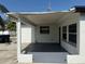 A rear covered porch featuring windows, a door, and fresh gray concrete at 740 7Th Sw Ave, Largo, FL 33770