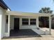 A rear covered porch with exterior door, windows, and a newly painted gray concrete pad at 740 7Th Sw Ave, Largo, FL 33770