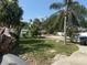 A spacious backyard with mature trees, chain link fence, and a fire pit area at 740 7Th Sw Ave, Largo, FL 33770