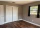 This bedroom features hardwood floors, a window with curtains, and a white closet with sliding doors at 740 7Th Sw Ave, Largo, FL 33770