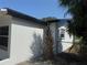 Exterior side shot of home's stucco construction and dark trim against blue sky at 740 7Th Sw Ave, Largo, FL 33770
