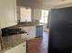 Cozy kitchen equipped with granite counters, white cabinetry, a dishwasher, and terracotta-style floors at 740 7Th Sw Ave, Largo, FL 33770
