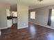 Open living room features wood flooring flowing into adjacent kitchen and sunny window at 740 7Th Sw Ave, Largo, FL 33770