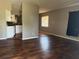 Open living room features wood flooring flowing into adjacent kitchen and sunny window at 740 7Th Sw Ave, Largo, FL 33770