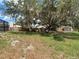 Large backyard features mature trees and a wooden fence, providing privacy at 7511 Laurel Oak Ct, Port Richey, FL 34668