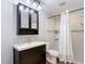 Bright bathroom features a dark vanity, a mirror, and a shower-tub combo at 7511 Laurel Oak Ct, Port Richey, FL 34668
