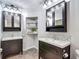 Dual sink bathroom with dark vanities, mosaic tile accents, and updated lighting at 7511 Laurel Oak Ct, Port Richey, FL 34668