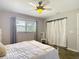 Bright bedroom with ceiling fan, gray curtains, and closet with white curtains at 7511 Laurel Oak Ct, Port Richey, FL 34668