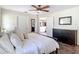 Bright bedroom featuring a ceiling fan, a large bed with white linens, and dark wood furniture at 7511 Laurel Oak Ct, Port Richey, FL 34668
