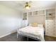 Bright bedroom with built-in shelving, dressers, ceiling fan and a white metal bed frame at 7511 Laurel Oak Ct, Port Richey, FL 34668
