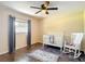 A cozy, bright bedroom, complete with a white crib, rocking chair, and ceiling fan at 7511 Laurel Oak Ct, Port Richey, FL 34668