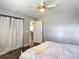 Bright bedroom with a ceiling fan and closet with white curtains; view to living spaces beyond at 7511 Laurel Oak Ct, Port Richey, FL 34668