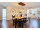 Dining area with long wooden table, seating for six, modern light fixture and minimalist decor at 7511 Laurel Oak Ct, Port Richey, FL 34668