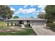 Charming single-story home featuring manicured landscaping, a two-car garage, and a welcoming entrance under a partly cloudy sky at 7511 Laurel Oak Ct, Port Richey, FL 34668
