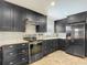 Open kitchen features stainless steel appliances, dark cabinets, mosaic backsplash and stone countertops at 7511 Laurel Oak Ct, Port Richey, FL 34668