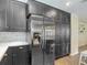 Bright kitchen features stainless steel appliances, dark cabinetry, quartz counters and tiled backsplash at 7511 Laurel Oak Ct, Port Richey, FL 34668
