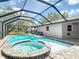 Inviting pool and spa enclosed by a screen, with a brick paved patio and views of the backyard at 7511 Laurel Oak Ct, Port Richey, FL 34668