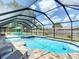 Beautiful pool area featuring a screened enclosure, a spa, and outdoor seating for relaxation and entertaining at 7511 Laurel Oak Ct, Port Richey, FL 34668