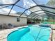 Sparkling pool and spa with a screened enclosure, surrounded by a well-maintained patio area at 7511 Laurel Oak Ct, Port Richey, FL 34668