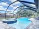 Tranquil pool and hot tub area with screened enclosure, providing a private outdoor oasis at 7511 Laurel Oak Ct, Port Richey, FL 34668