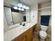 Cozy bathroom with wooden cabinets, a mirror and white fixtures at 880 Mandalay Ave # C412, Clearwater Beach, FL 33767