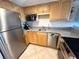 Functional kitchen with wooden cabinets, granite countertops and modern appliances at 880 Mandalay Ave # C412, Clearwater Beach, FL 33767