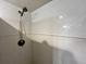 Bathroom shower with white tiled walls and metal shower head at 880 Mandalay Ave # C412, Clearwater Beach, FL 33767