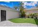 Backyard featuring artificial turf, pavers, mature palms, and a modern garage at 10003 Brompton Dr, Tampa, FL 33626