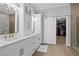 Elegant bathroom featuring a double vanity, custom mirrors, and a sliding barn door to the walk-in closet at 10003 Brompton Dr, Tampa, FL 33626