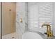 Beautiful bathroom with a marble shower, soaking tub, and gold fixtures, with white shuttered windows at 10003 Brompton Dr, Tampa, FL 33626