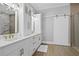 Elegant bathroom featuring a double vanity, custom mirrors, and a sliding barn door to the walk-in closet at 10003 Brompton Dr, Tampa, FL 33626