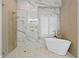 Bright bathroom featuring a freestanding tub, walk-in shower, and marble tile at 10003 Brompton Dr, Tampa, FL 33626