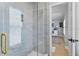 Modern bathroom featuring a glass shower with marble tiling and gold fixtures leading into another room at 10003 Brompton Dr, Tampa, FL 33626