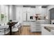 Modern kitchen and dining area featuring white cabinets, marble countertops, stainless steel appliances, and bright lighting at 10003 Brompton Dr, Tampa, FL 33626