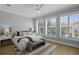 Bright bedroom with light wood floors, a gray bench, and view of the pool through shuttered windows at 10003 Brompton Dr, Tampa, FL 33626