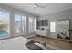 Airy bedroom with light wood floors, a comfortable gray bench, and view of the pool through shuttered windows at 10003 Brompton Dr, Tampa, FL 33626