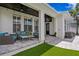 Covered patio with comfortable seating overlooking a well-maintained backyard with artificial turf at 10003 Brompton Dr, Tampa, FL 33626